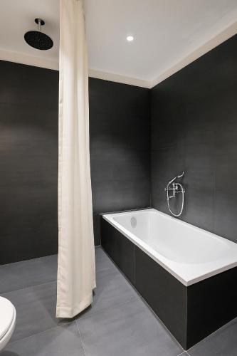 a bathroom with a white bath tub and a toilet at Aarambh By The Sky Imperial, Nathdwara in Nāthdwāra