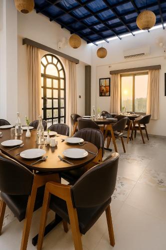 a dining room with wooden tables and chairs at Aarambh By The Sky Imperial, Nathdwara in Nāthdwāra