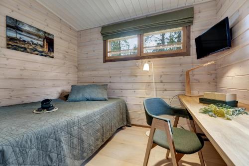 a bedroom with a bed and a desk and a television at Lapland Fellas - Äkäslompolo in Äkäslompolo