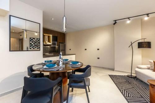 Un comedor con una mesa y sillas y un sofá. en Luxury 2 BR - 1 Ensuite - POOL - By Beithady - BH-26-402, en New cairo