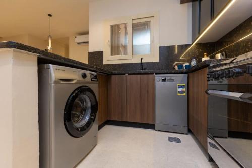 una cocina con lavadora y fregadero en Luxury 2 BR - 1 Ensuite- POOL - By Beithady - BH-26-102, en New cairo