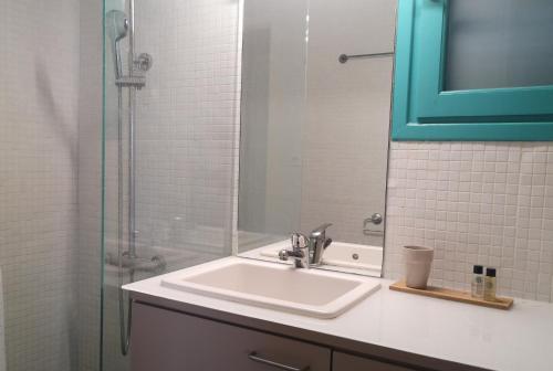 a bathroom with a sink and a glass shower at The Iconpainter Peroulia Villa in Kómboi