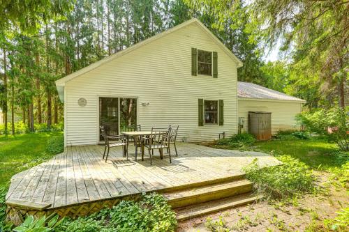 a house with a table and chairs on a wooden deck at Less Than 1 Mi to ATV Trails Cadillac Golf Retreat! in Cadillac