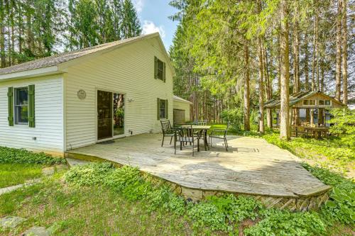 a wooden deck with a table and chairs in front of a house at Less Than 1 Mi to ATV Trails Cadillac Golf Retreat! in Cadillac