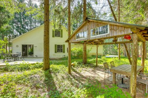 a wooden house with a picnic table and a bench at Less Than 1 Mi to ATV Trails Cadillac Golf Retreat! in Cadillac