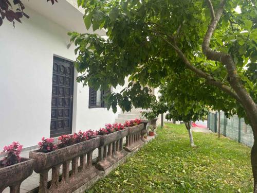 a fence with pink flowers in front of a house at Apartman Serdjo 