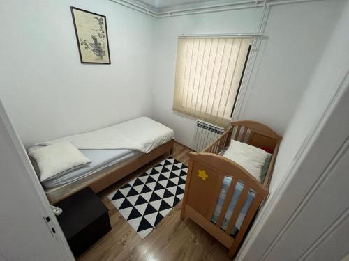 a small bedroom with two beds and a window at Apartman Serdjo 