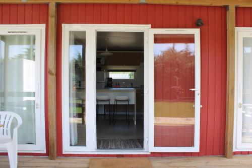 an open door of a red house with a kitchen at Padel Camp House in Cascais