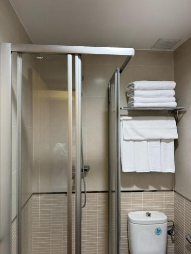 a bathroom with a shower and a toilet and towels at El Camino Casa Boutique in Cifuentes