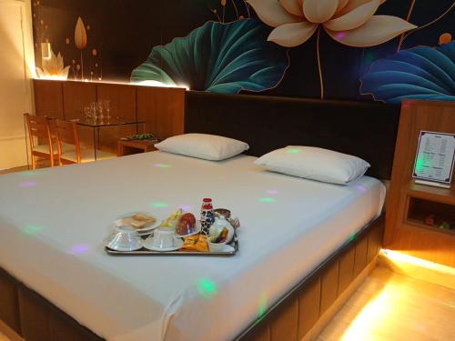 a bed with a tray of food on it at STILLUS - Hotel e Motel in Imperatriz