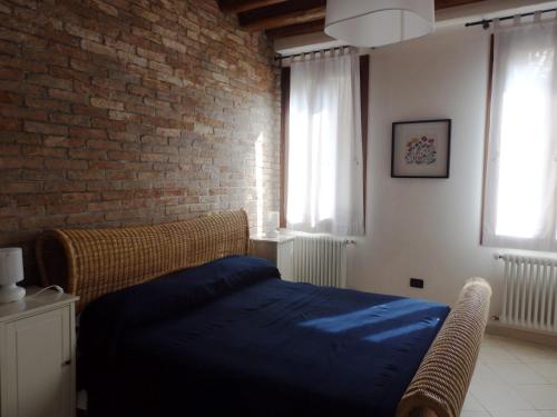 ヴェネツィアにあるappartamento alla Creaのレンガの壁、ベッド付きのベッドルーム1室