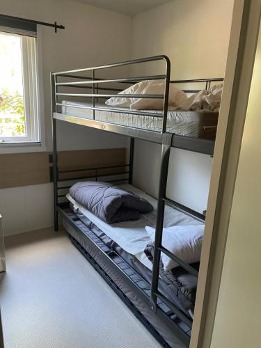 deux lits superposés dans une chambre avec fenêtre dans l'établissement Magnifique mobilhome-2 sdb-Camping 5 étoiles, à Biscarrosse
