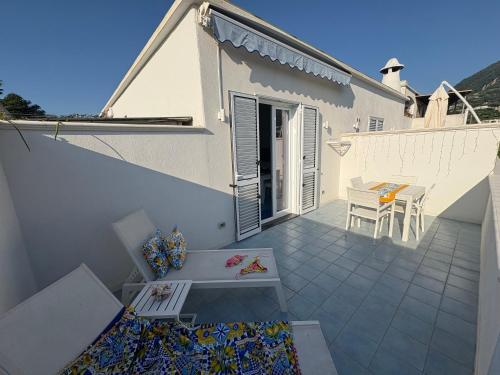a white house with a balcony with a table at Bellessere in vacanza Forio d’ Ischia in Forio d'Ischia