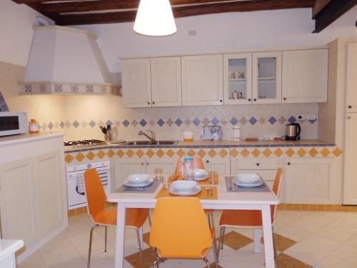 cocina con mesa blanca y sillas y cocina con armarios blancos en appartamento alla Crea, en Venecia