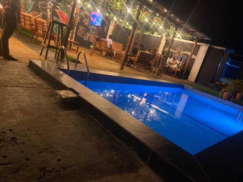a swimming pool at night with people sitting at Richj luxury apartment in Benin City