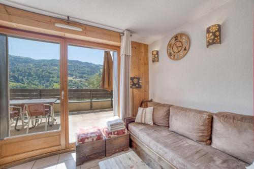 un salon avec un canapé et une grande fenêtre dans l'établissement Duplex familial - Piscine intérieure, à Saint-Gervais-les-Bains
