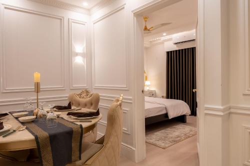 ein Hotelzimmer mit einem Tisch und einem Bett in der Unterkunft The Versailles Suite A Designer Home in Dhaka in Dhaka