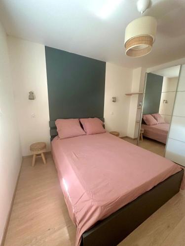 a bedroom with a large bed with pink sheets at Nice and cosy appartement Annecy in Annecy