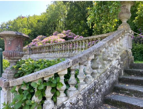 an old stone fence with a bunch of flowers at Manoir de Daubeuf in Daubeuf-Serville