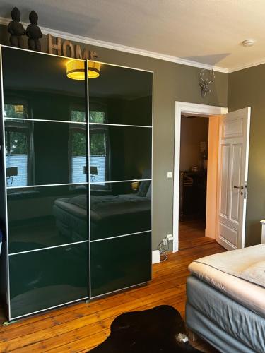 a large glass cabinet in a bedroom with a bed at Deluxe Altbaucharme in zentraler Lage in Kiel
