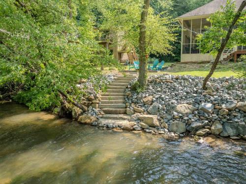a set of stairs next to a river with a house at Riverfront Home w Gameroom & Screened Porch in Ellijay