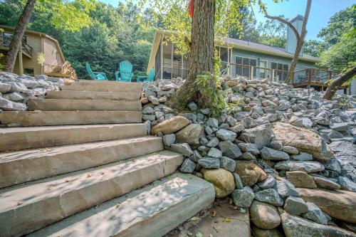 a rock retaining wall with stairs and a tree at Riverfront Home w Gameroom & Screened Porch in Ellijay