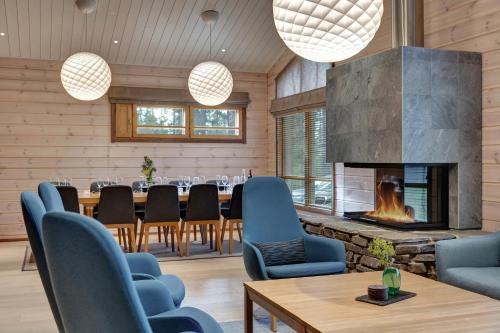 a dining room with a fireplace and a table and chairs at Lapland Fellas - Äkäslompolo in Äkäslompolo