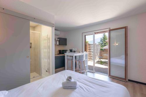 une chambre avec un lit et une vue sur une cuisine dans l'établissement Cabana & Studio Alpin Annecy - Terrasse Parking, à Argonay