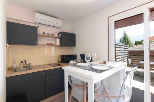 a kitchen with a table with wine glasses on it at Cabana & Studio Alpin Annecy - Terrasse Parking in Argonay