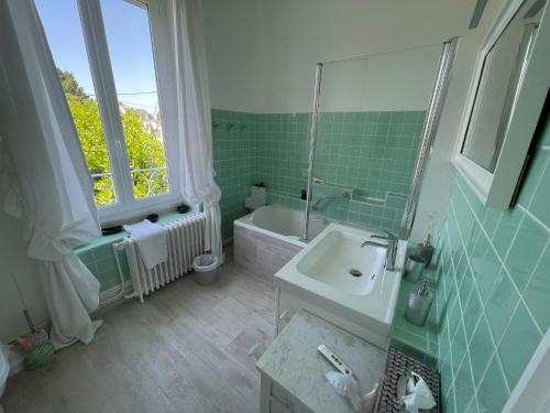La salle de bains est pourvue d'un lavabo, d'une baignoire et d'une fenêtre. dans l'établissement Villa sur le port de La Baule - Le Pouliguen, au Pouliguen