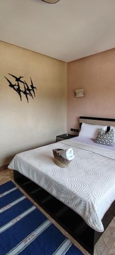 a bedroom with a bed with a branch on the wall at Taghazout Hillside Apartment with Swimming Pool in Taghazout