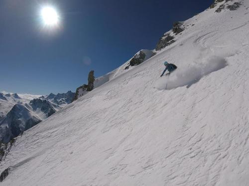 a person is skiing down a snow covered mountain at Joli studio confortable et tout équipé au pied du col d'Izoard in Arvieux