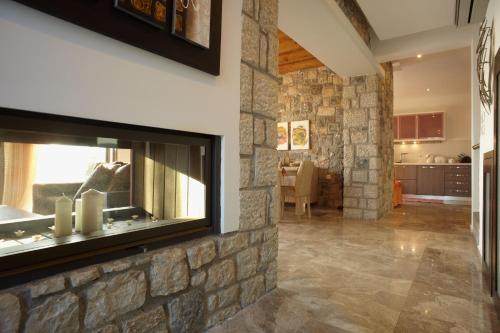 a living room with a stone wall with a fireplace at Blue Dream Exclusive villas privees in Pefki Rhodes