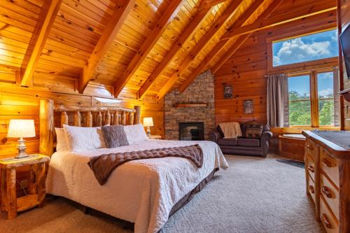 a log cabin bedroom with a bed and a fireplace at Bear Essentials Lodge By Avada Properties in Sevierville