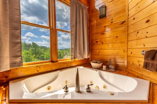 a bath tub in a bathroom with a window at Bear Essentials Lodge By Avada Properties in Sevierville