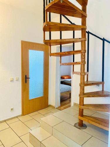 a wooden spiral staircase in a room with a door at Komplettes Monteur Haus in Hannover