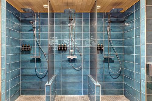 a bathroom with blue tiled walls and a shower at Lapland Fellas - Äkäslompolo in Äkäslompolo