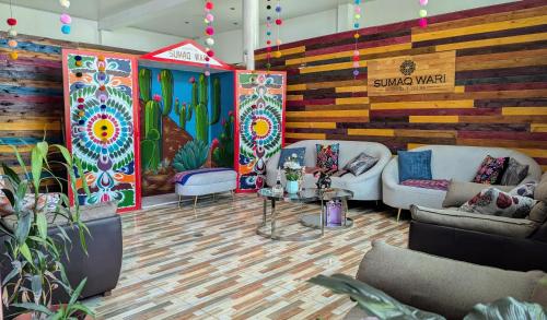 a lobby with couches and a wall with a mural at Sumaq Wari Hotel in Ayacucho
