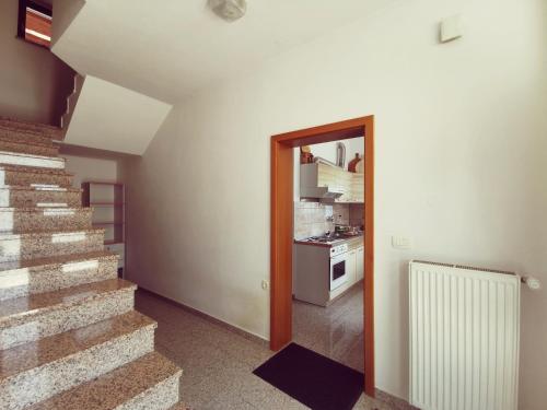 a hallway with a staircase and a kitchen in a house at Apartma Pristavica in Veliki Gaber