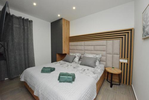 a bedroom with a bed with two green pillows on it at Amantis in Zadar