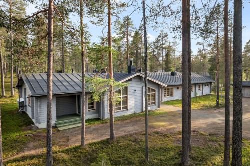 a house in the woods with trees at Lapland Fellas - Äkäslompolo in Äkäslompolo