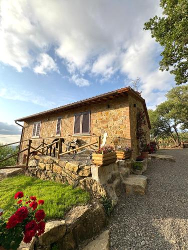 カスティリオーネ・ドルチャにあるAgriturismo Colle Serenoの花の目の前の小さなレンガ造りの建物