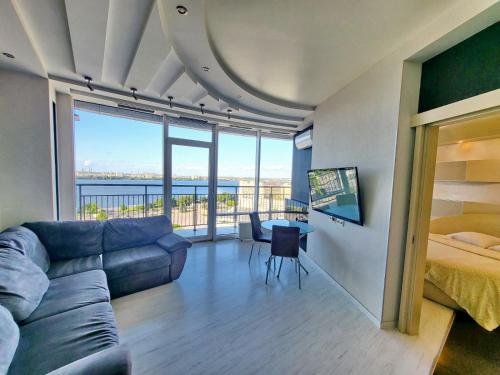 a living room with a couch and a bed at Семейные апартаменты в Мост Сити зал и 1 спальня, вид на реку, балкон Ванна in Dnipro