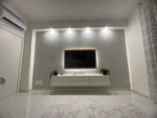a living room with a television on a white wall at Alloggio comodo a Rapallo - Vicino al Mare in Rapallo