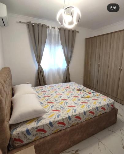 a bedroom with a bed with a colorful comforter at Korca Apartament Koci in Korçë