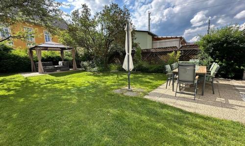 a yard with a table and chairs and an umbrella at DC Room Luca in Zeltweg