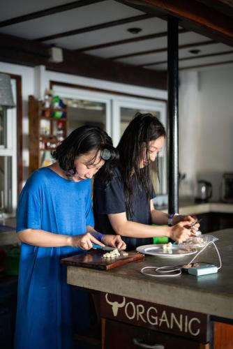 two women standing at a counter preparing food at The Yak Lake House - Hostal Bacalar in Bacalar
