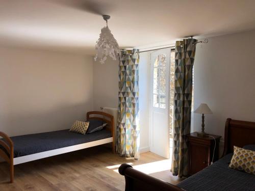 une chambre avec deux lits et une fenêtre dans l'établissement Louhmari, à Sarlat-la-Canéda