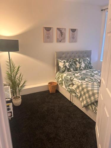 a bedroom with a bed and a potted plant at Stylish 1 Bedroom Apartment Near Sheffield in Kimberworth