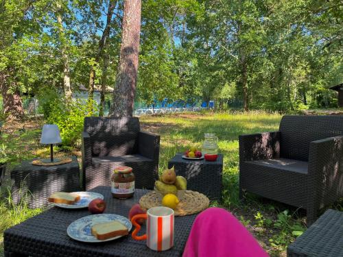 ein Tisch mit Essen darauf und zwei Stühlen in der Unterkunft Jolie maison au cœur de la Marina Talaris Lacanau in Lacanau